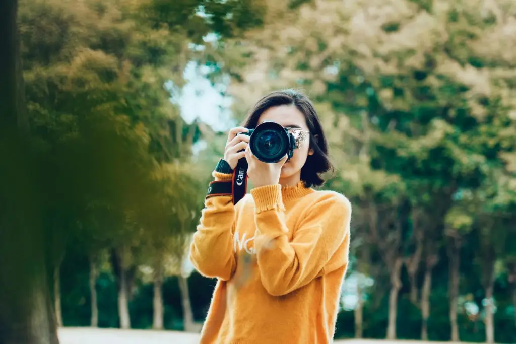 Kvinnelig fotograf som ser inn i kamera